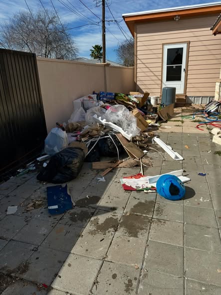 Cluttered backyard patio with trash bags and debris before Super Trash Pros cleanout in the Rio Grande Valley