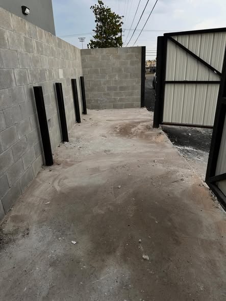 Empty alleyway with bare concrete floor after Super Trash Pros hauled away the construction debris